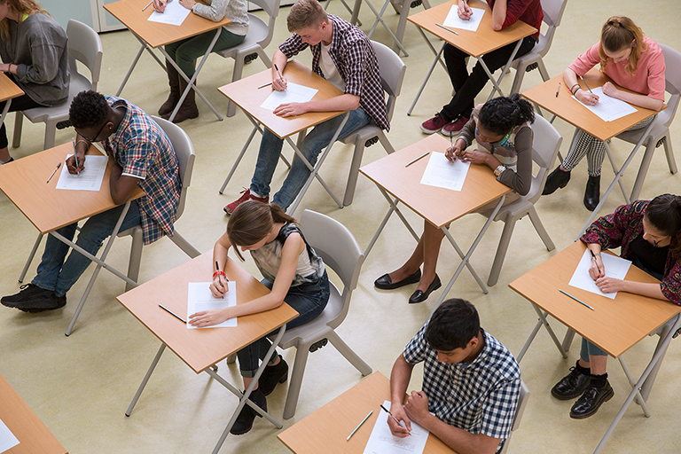 Students in a classroom work on a standardized test. Students in a classroom work on a standardized test.