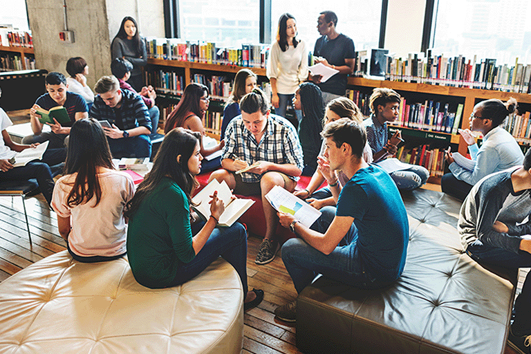 Students working together in a library setting Students working together in a library setting