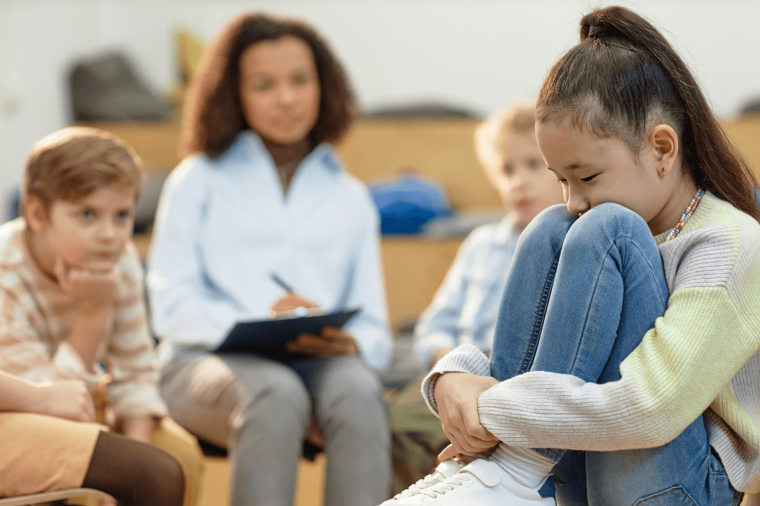 Kids and a counselor sitting in a group session. Kids and a counselor sitting in a group session.
