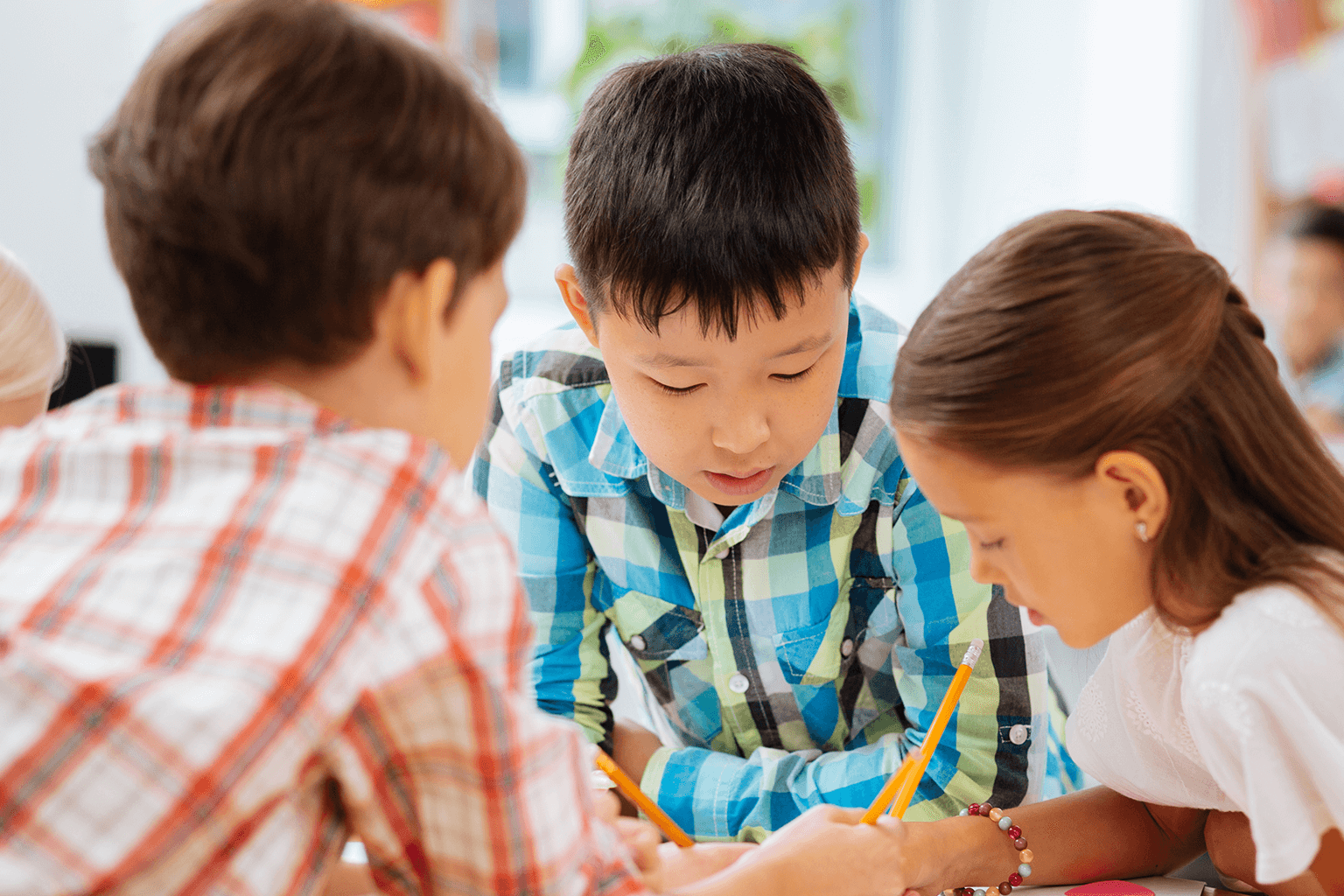 Kids working together at a table. Kids working together at a table.