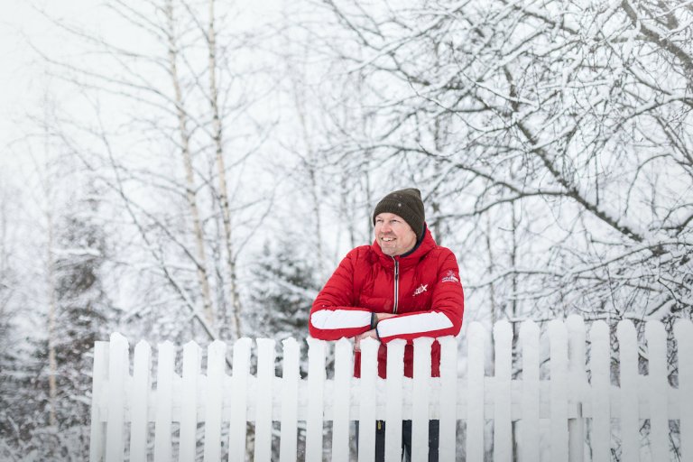 Mann utendørs i snøen ved et gjerde