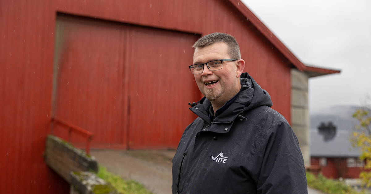 Smilende mann pÄ et gÄrdstun
