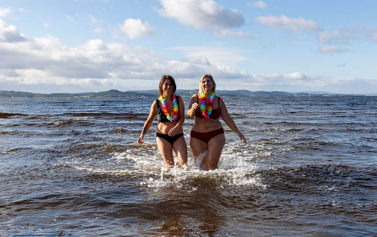 To damer i bikini med fargerike kranser rundt halsen