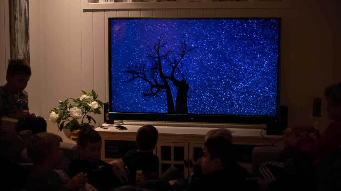 Familie sitter foran TV skjermen og ser en film