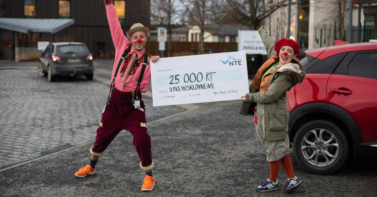 To sykehusklovner holder en gavesjekk på 25 000 kroner
