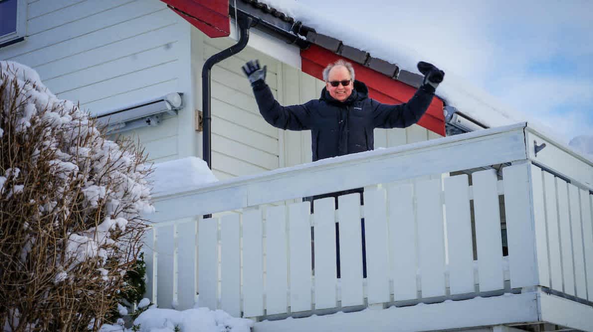 Jublende glad mann på et hvitmalt veranda