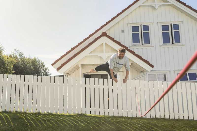 Mann hopper over gjerde