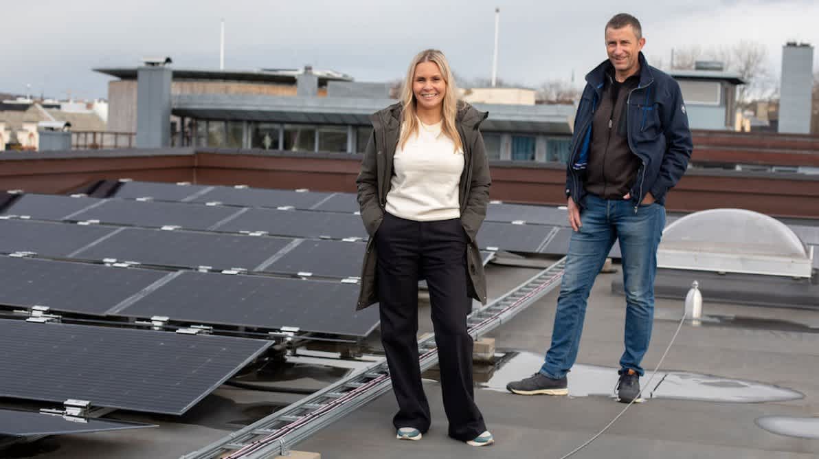 Lisa og Steinar foran flere solceller pÄ et tak