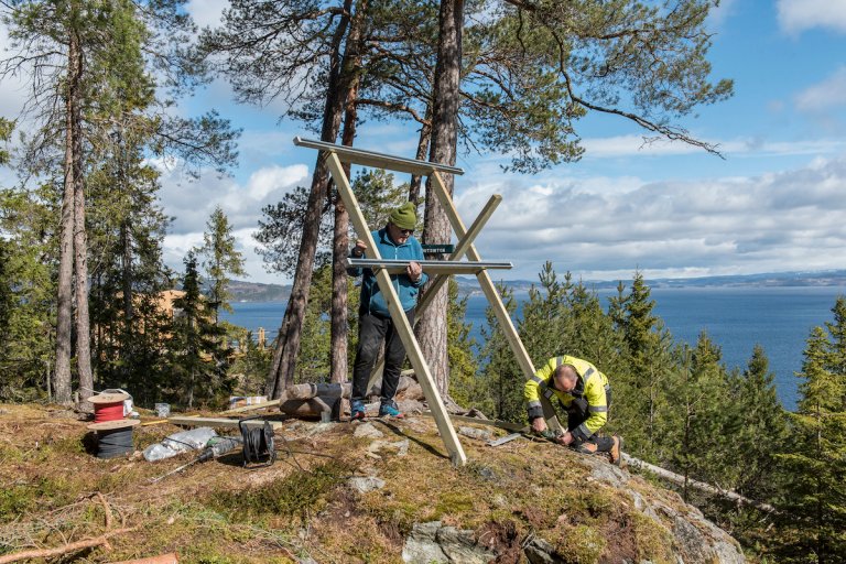 Elektrikere monterer stativ for solceller i skogen