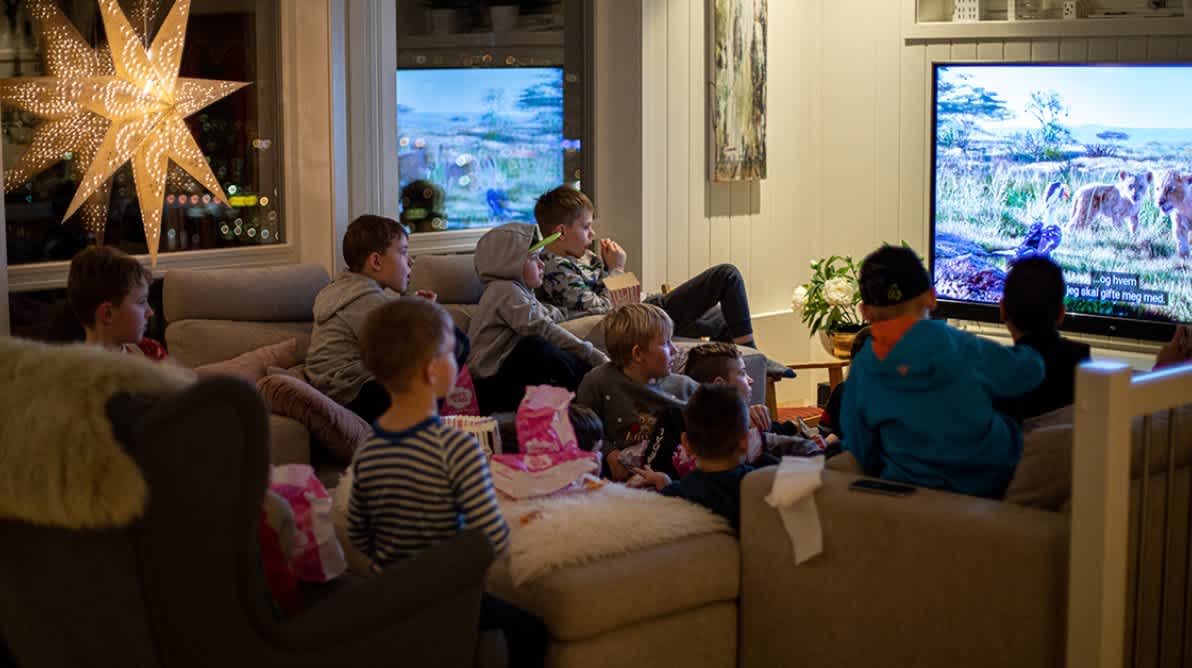 Mange barn sitter sammen og ser pÄ TV