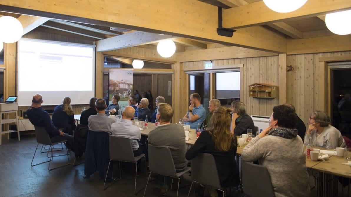 Gruppe mennesker ser pÄ en presentasjon om Solceller