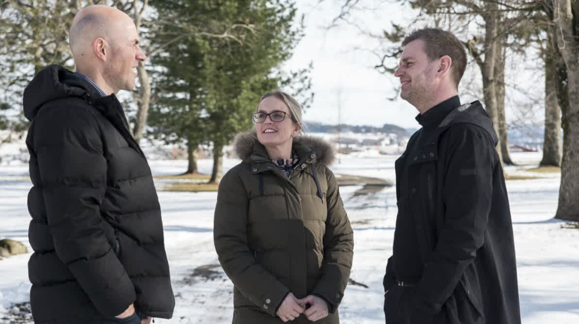 Tre personer som snakker sammen