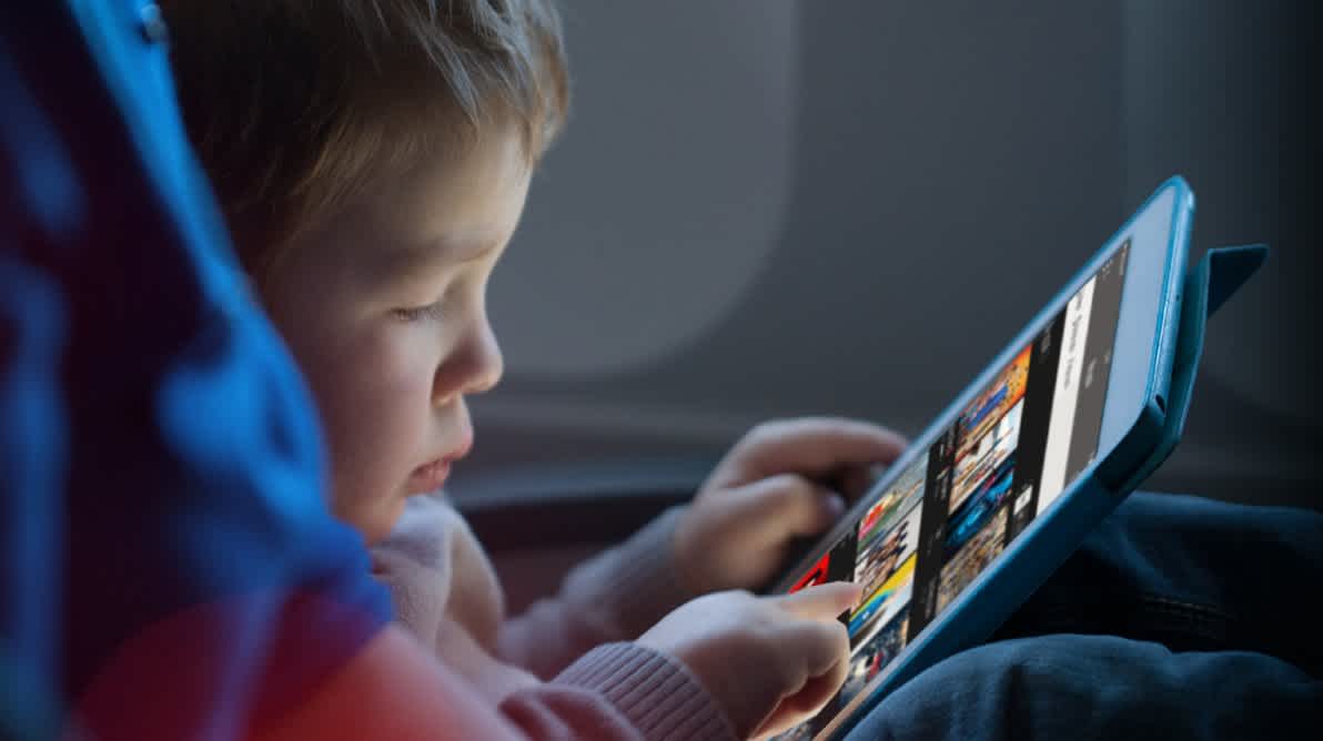 Barn sitter i bilen og ser pÄ TV pÄ en iPad