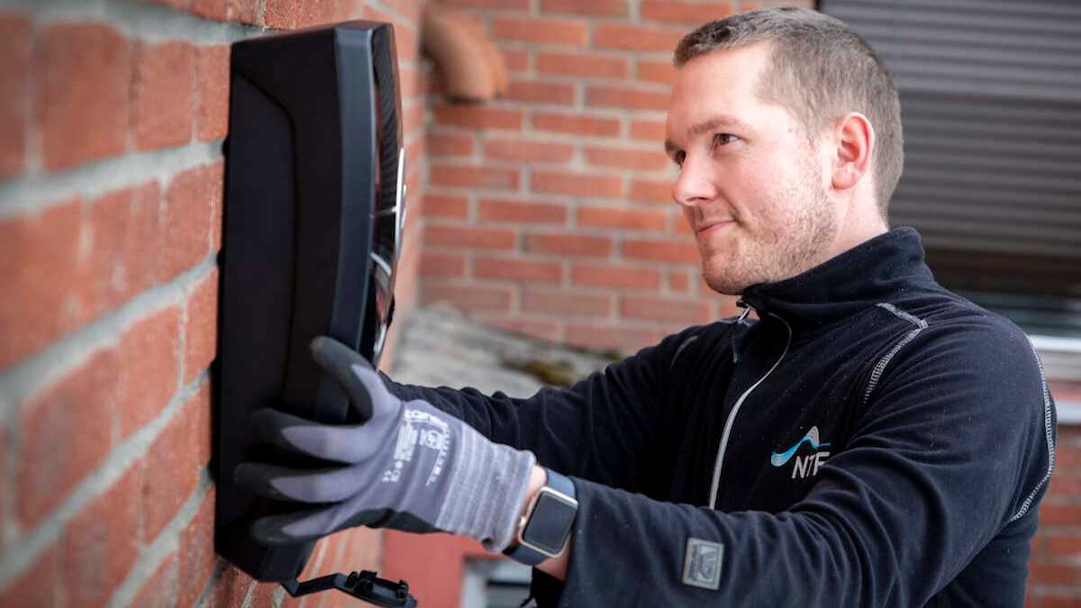 Elektriker fra NTE monter elbillader pÄ en vegg