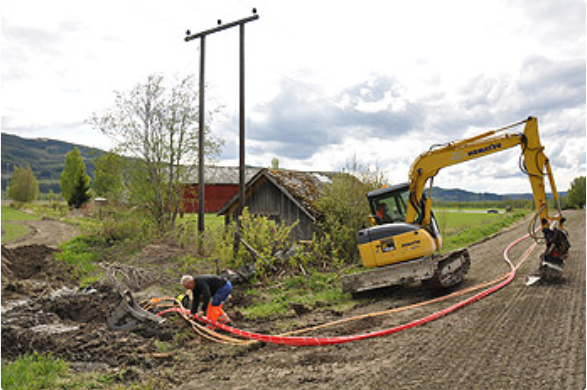 Gravemaskin i arbeid for Ă„ grave til bygdefiber