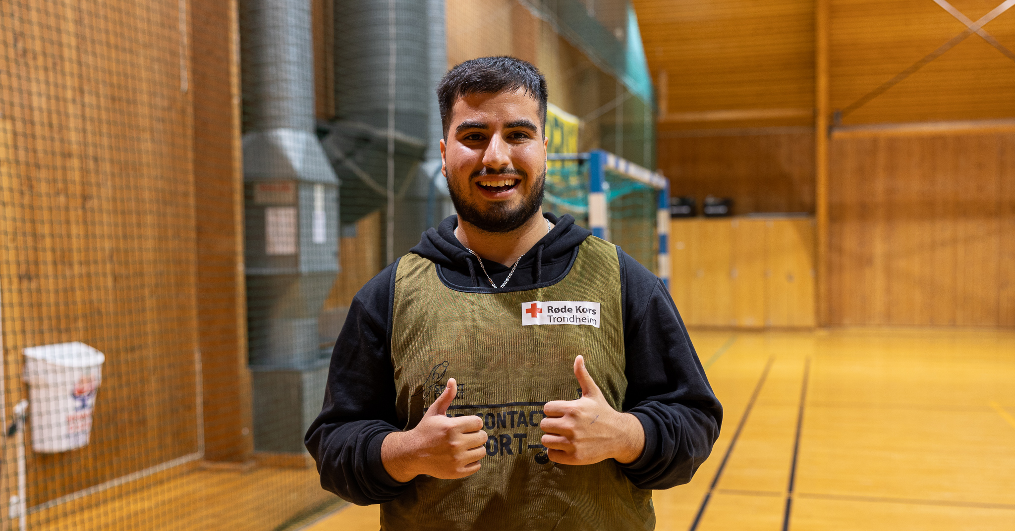 Smilende mann som gir tommel opp