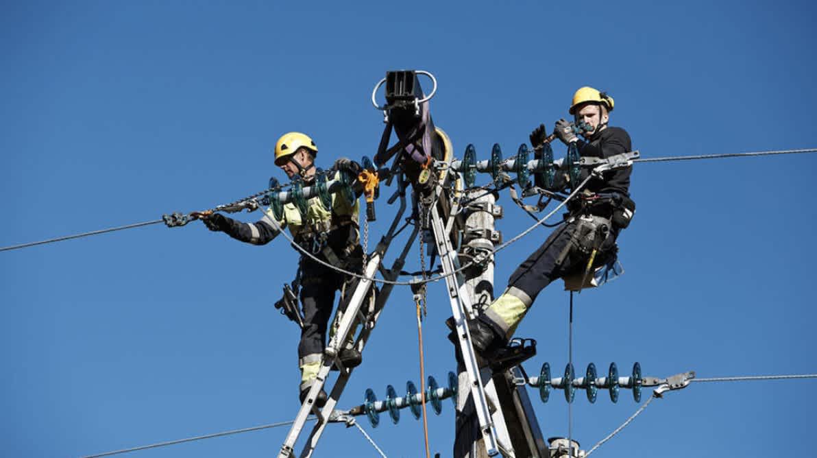 Elektrikkere jobber oppe i en strĂžmmast