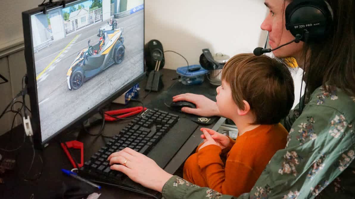 Far og sønn gamer foran samme pc skjerm