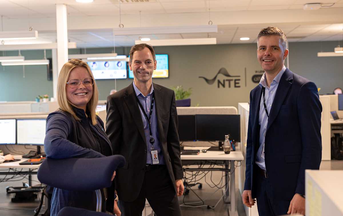 En kvinne og to menn i et kontorlandskap