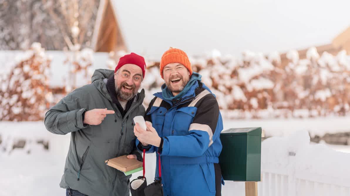 To menn utendÞrs peker pÄ en fjutt mens de smiler