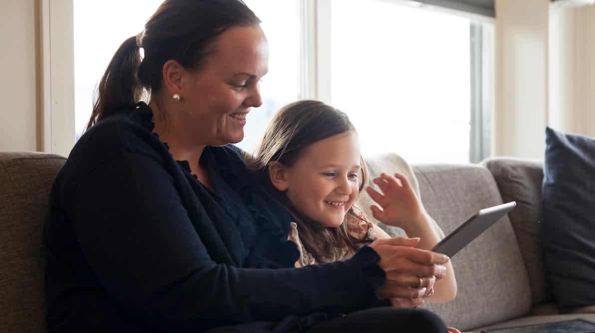 Mor og datter som ser på en iPad sammen