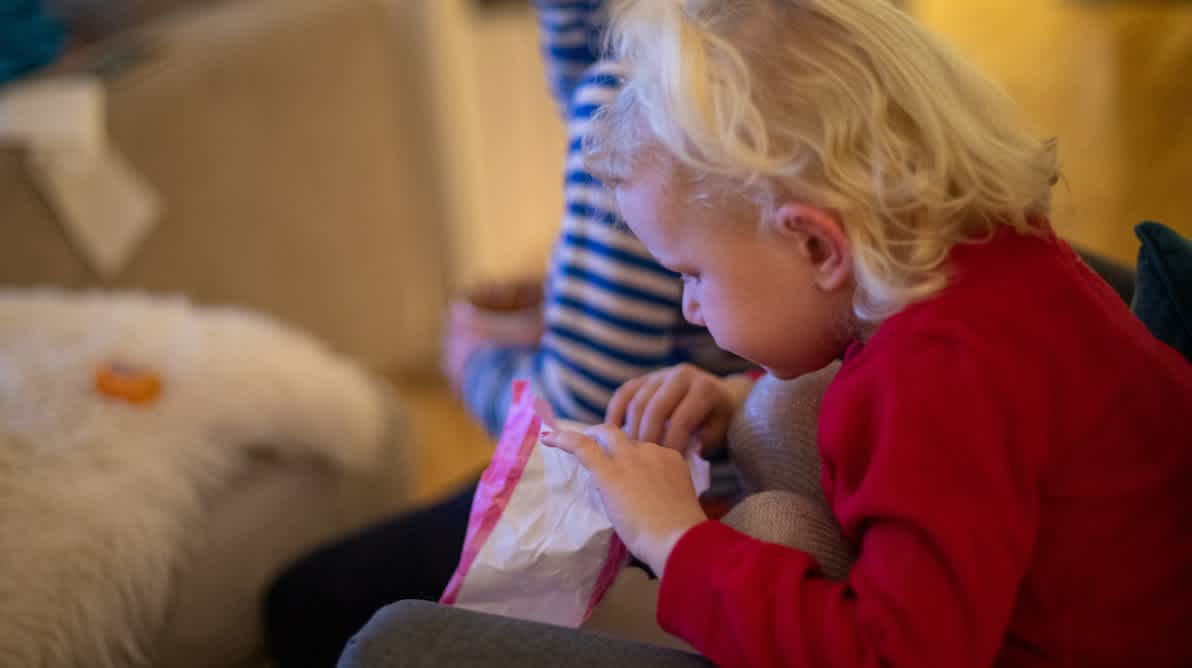 Barn med en pose godteri foran TV