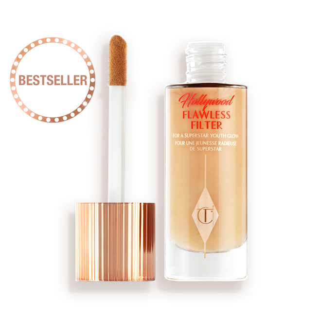 HFF-2.5-LEGENDARY-PDP 1 An open glow-boosting primer in a glass bottle with a rose gold-coloured lid with a doe-foot applicator.