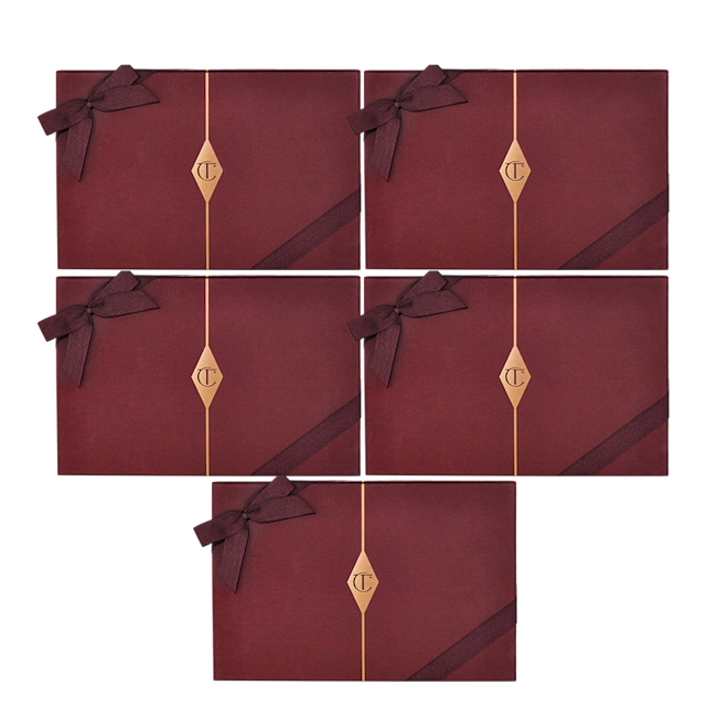 Charlotte's Complete Magic Holiday Collection boxes Five, dark crimson-coloured gift boxes with matching bows on them and the CT logo printed in the middle in gold.