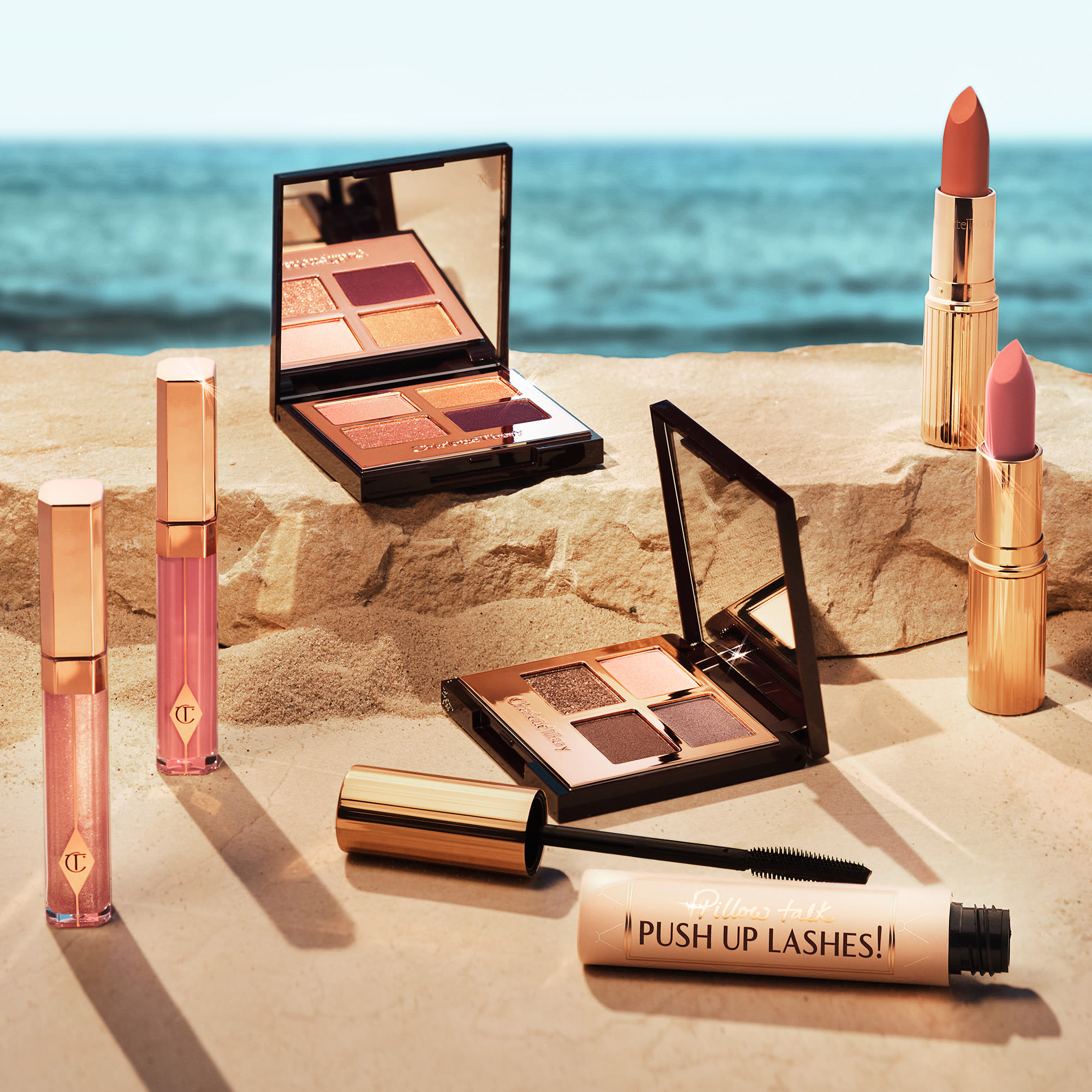 Summer makeup banner Banner with a collection of lip glosses, eyeshadow palettes, and lipsticks for the perfect summer makeup look.