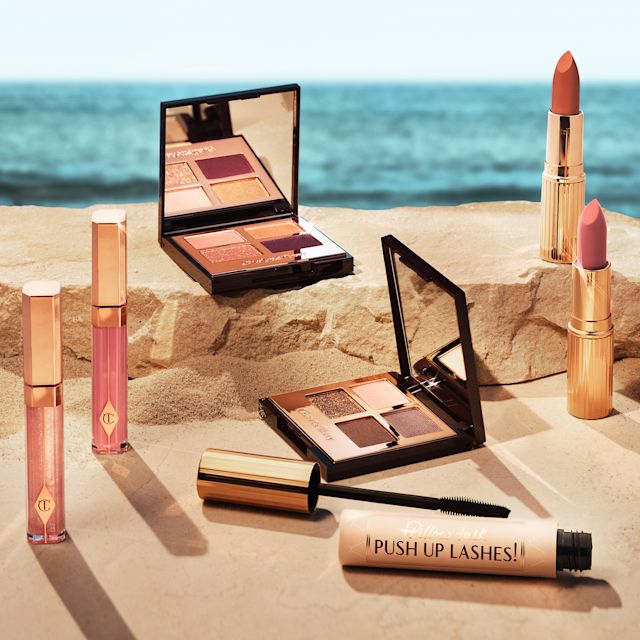 Summer makeup banner Banner with a collection of lip glosses, eyeshadow palettes, and lipsticks for the perfect summer makeup look.