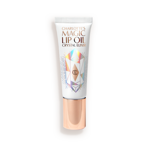 Magic Lip Oil Crystal Elixir closed A lip oil in a white coloured tube with reflective geometric patterns on it in silver colour and a rose-gold-coloured lid.