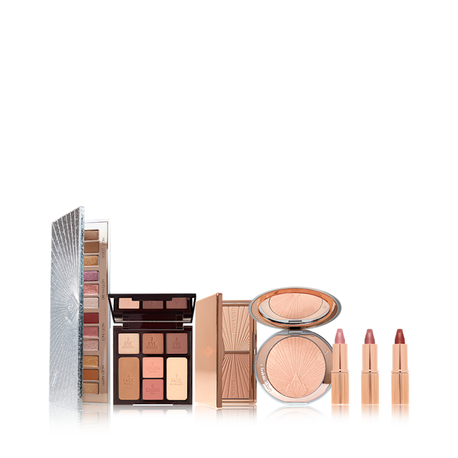 Charlotte's Ultimate Gift of Trinkets Stocking Bundle open An open, 12-pan eyeshadow palette with a mirrored-lid in shades of pink, brown, gold, red, and beige, duo contour palette with a mirrored lid, glowy highlighter compact in a soft rose gold shade, and lipstick trio in three shades.