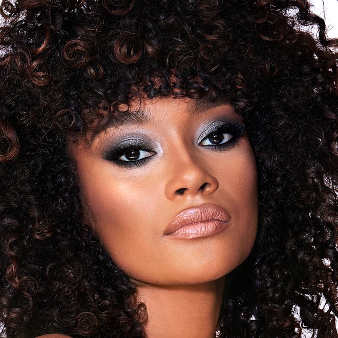 The Rock Chick look on deep tone model with brown eyes A deep-tone brunette model with brown eyes wearing smokey silvery eyeshadow with bronzed cheeks and glossy nude-peach lips.