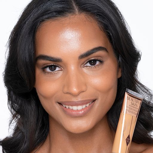 Beautiful Skin foundation in 10N on dark-tone model Dark-tone brunette model wearing glowy, skin-like foundation with a fresh, satin finish with a nude lipstick, and subtle eye makeup. view 2
