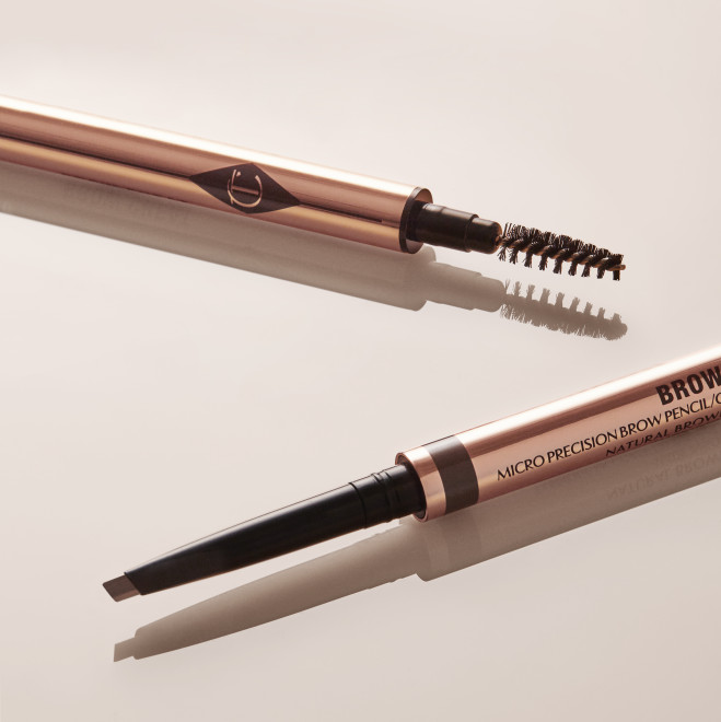 Close-up of a dual-ended eyebrow pencil and spoolie brush stick with gold-coloured sleek packaging.