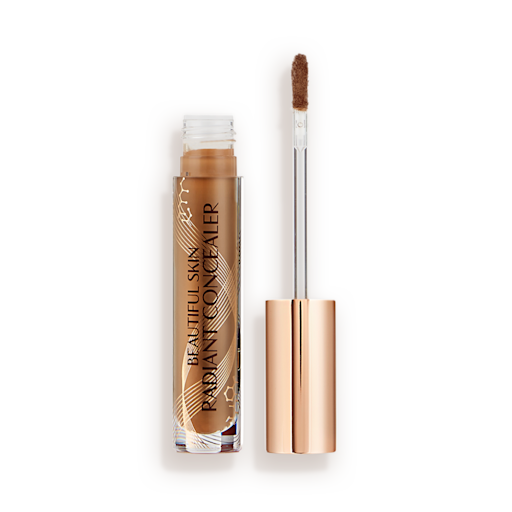 Beautiful Skin Radiant in Concealer in 12 lid removed Radiant concealer in a glass tube with its doe-foot applicator next to it with a gold-coloured handle.