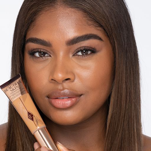 Beautiful Skin Foundation in 11W on deep-tone model Dark-tone brunette model wearing glowy, skin-like foundation with a satin finish with nude lipstick and subtle eye makeup.