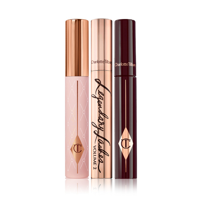 Three mascaras, one in a light pink tube with a gold-coloured lid, another in a gold-coloured tube with matching lid, and the last in dark crimson packaging.