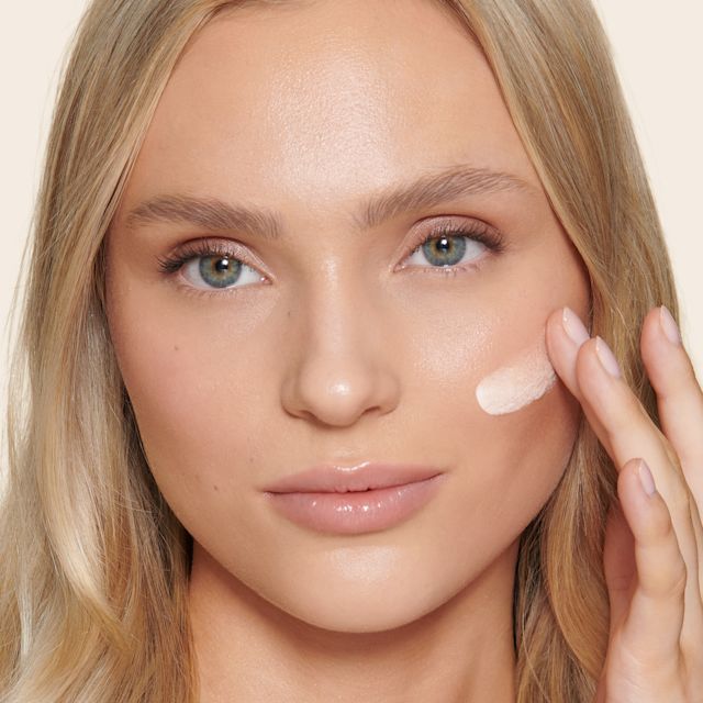 Unisex Healthy Glow model shot Model applying Unisex Healthy Glow tinted moisturiser for a minimal makeup look