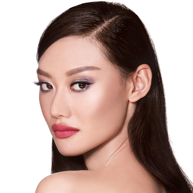 The Uptown Girl look on fair-tone model A fair-tone blonde model with brown eyes wearing shimmery lilac and champagne eye makeup with nude pink blush and a warm, coral lipstick.