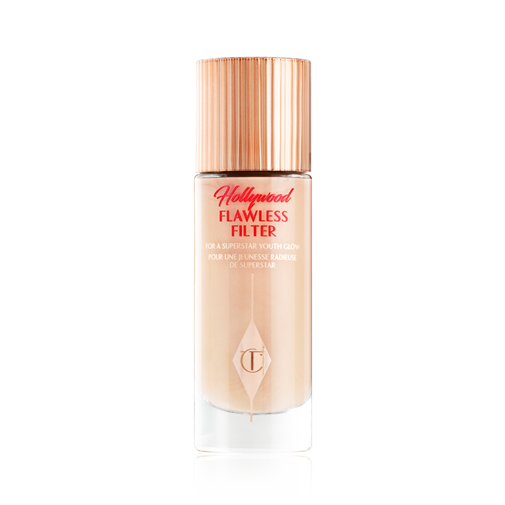 Hollywood Flawless Filter packshot for blog A closed, luminous primer in a light cool-toned-beige shade in a glass bottle with a gold-coloured lid.
