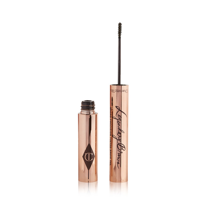 Open, tinted brow gel in a dark brown shade with a thin brush for precision, and a shiny, gold-coloured tube.