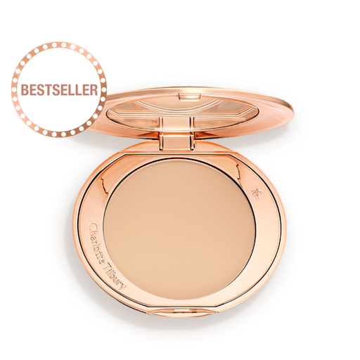 Airbrush Flawless Finish in Medium open An open, pressed powder compact in a light beige shade.