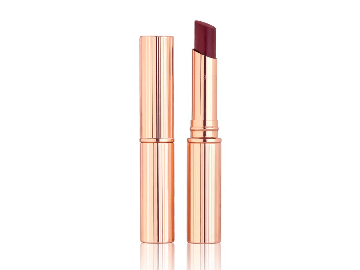 Superstar Lips in Confident Lips with and without lid Two glossy lipsticks in sheer, burgundy shade, one with its lid and the other with its lid removed, in gold-coloured packaging.