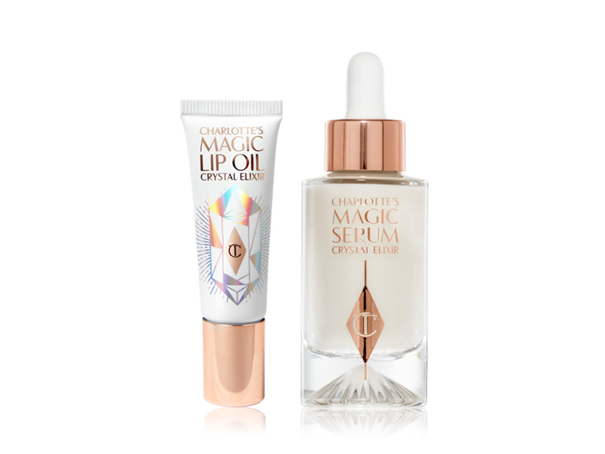 Magic Serum and Magic Lip Oil A lip oil in a white-coloured tube with reflective, geometric pattern in silver colour and a rose-gold-coloured lid with a luminous serum in a glass bottle with a dropper lid.