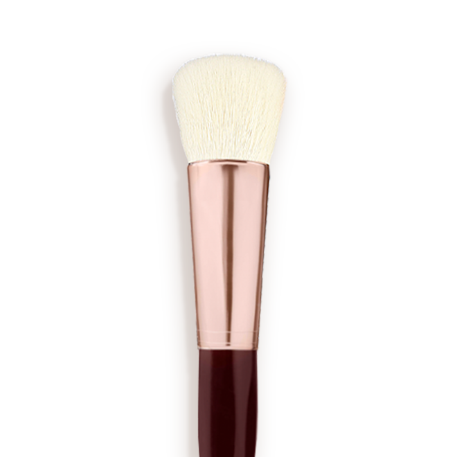 Magic Complexion Brush Close-up A face blending brush with cream-coloured bristles with a rose-gold and dark crimson handle.