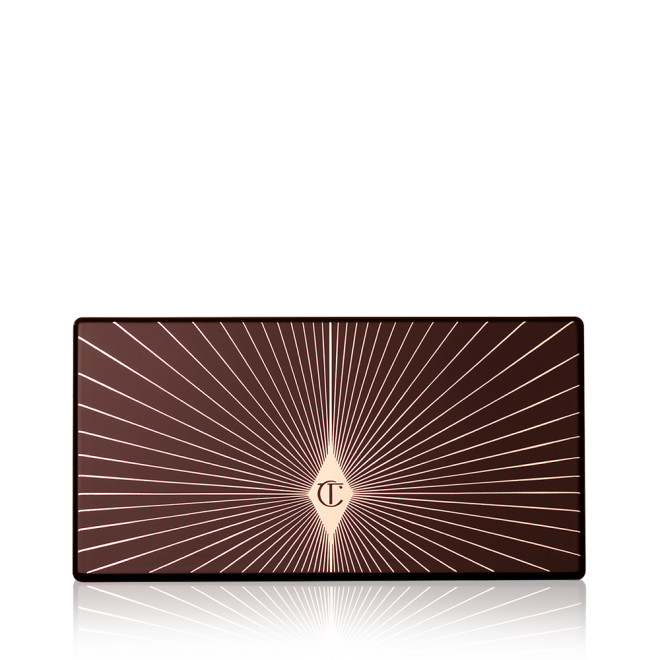 A closed eyeshadow palette with a black-coloured lid with a golden starburst patter on top.