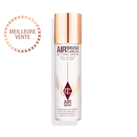 Airbrush Flawless Setting Spray sans son bouchon Une brume fixatrice ouverte dans un flacon transparent à côté de son bouchon doré.