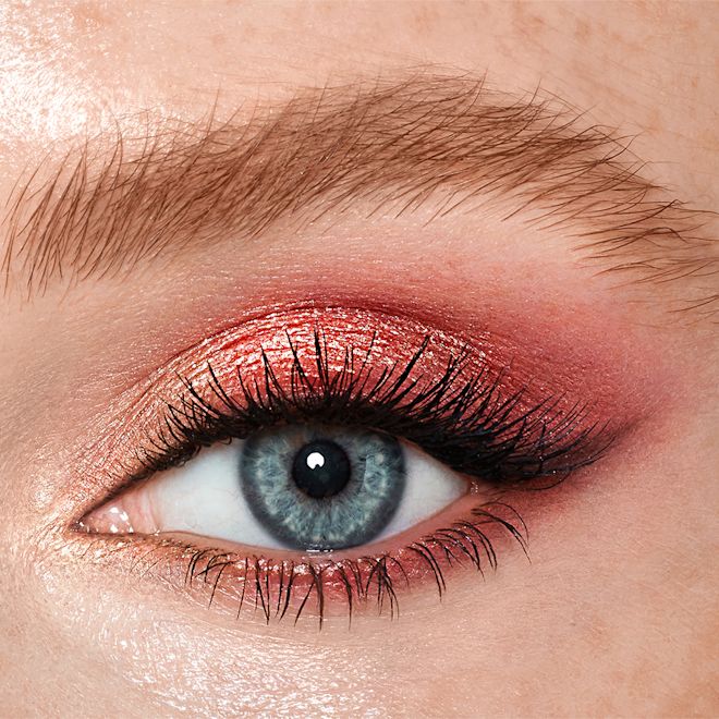 Walk of no shame Luxuspalettenaugen Single-eye close-up of a blue-eyed fair-tone model wearing shimmery rose gold, fawn, and berry-pink eye makeup.