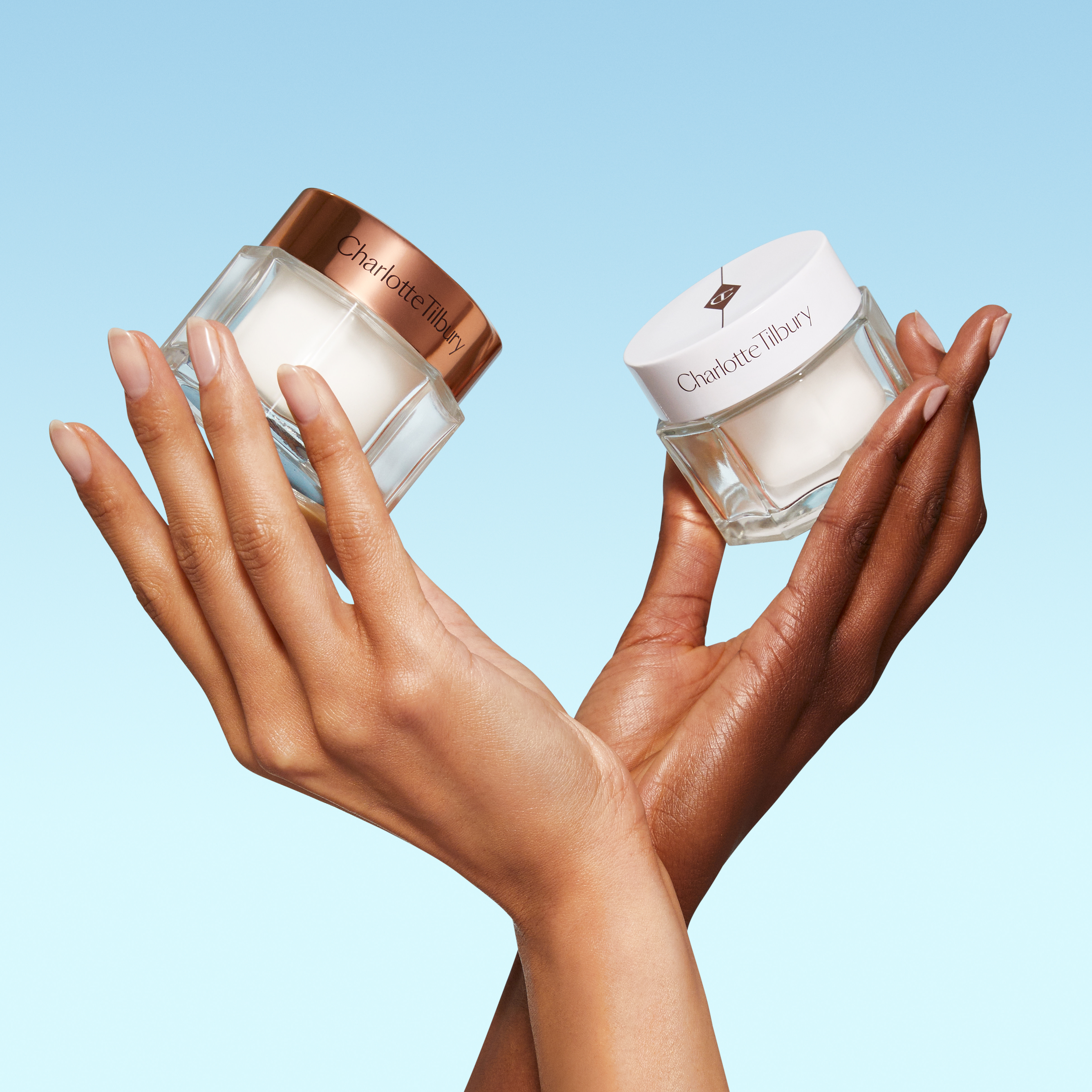 Hand models holding Charlotte's Magic Cream cream moisturiser and Charlotte's Magic Water Cream gel moisturiser
